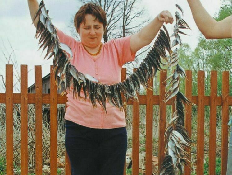 женщина с связкой сушеной рыбы